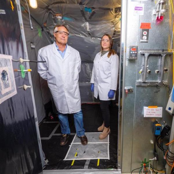 Professor Mark Hernandez and doctoral graduate Marina Nieto-Caballero stand inside a bioaerosol chamber in the Environmental Engineering disinfection laboratory at the Sustainability, Energy and Environment Complex (SEEC)