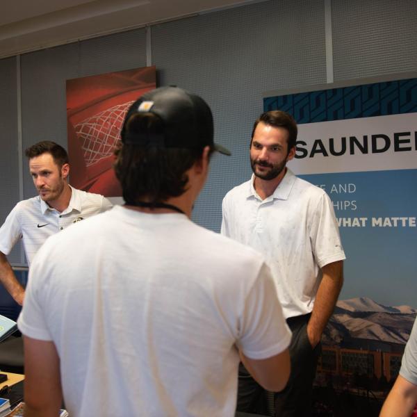 Conference participants visiting Saunders table