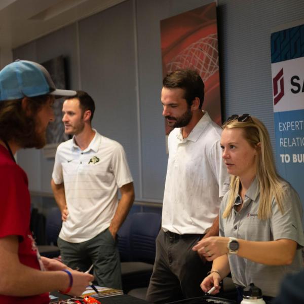 Conference participants visiting Saunders table