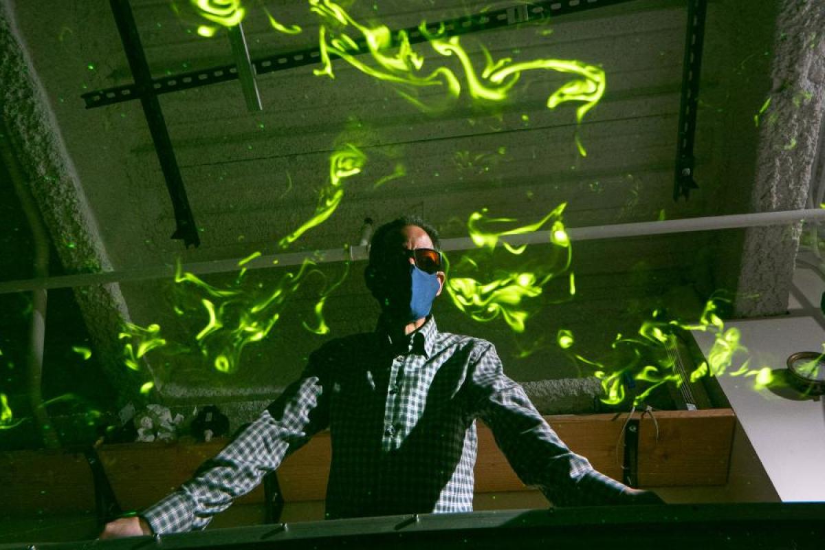 John Crimaldi watches as green laser light illuminates plumes in his lab's test flume.