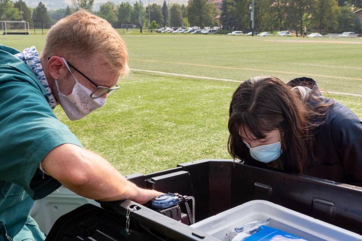 Cresten Mansfeldt and Katie Reeves examine a wastewater monitoring station that collects wastewater from the Kittredge residence hall complex.