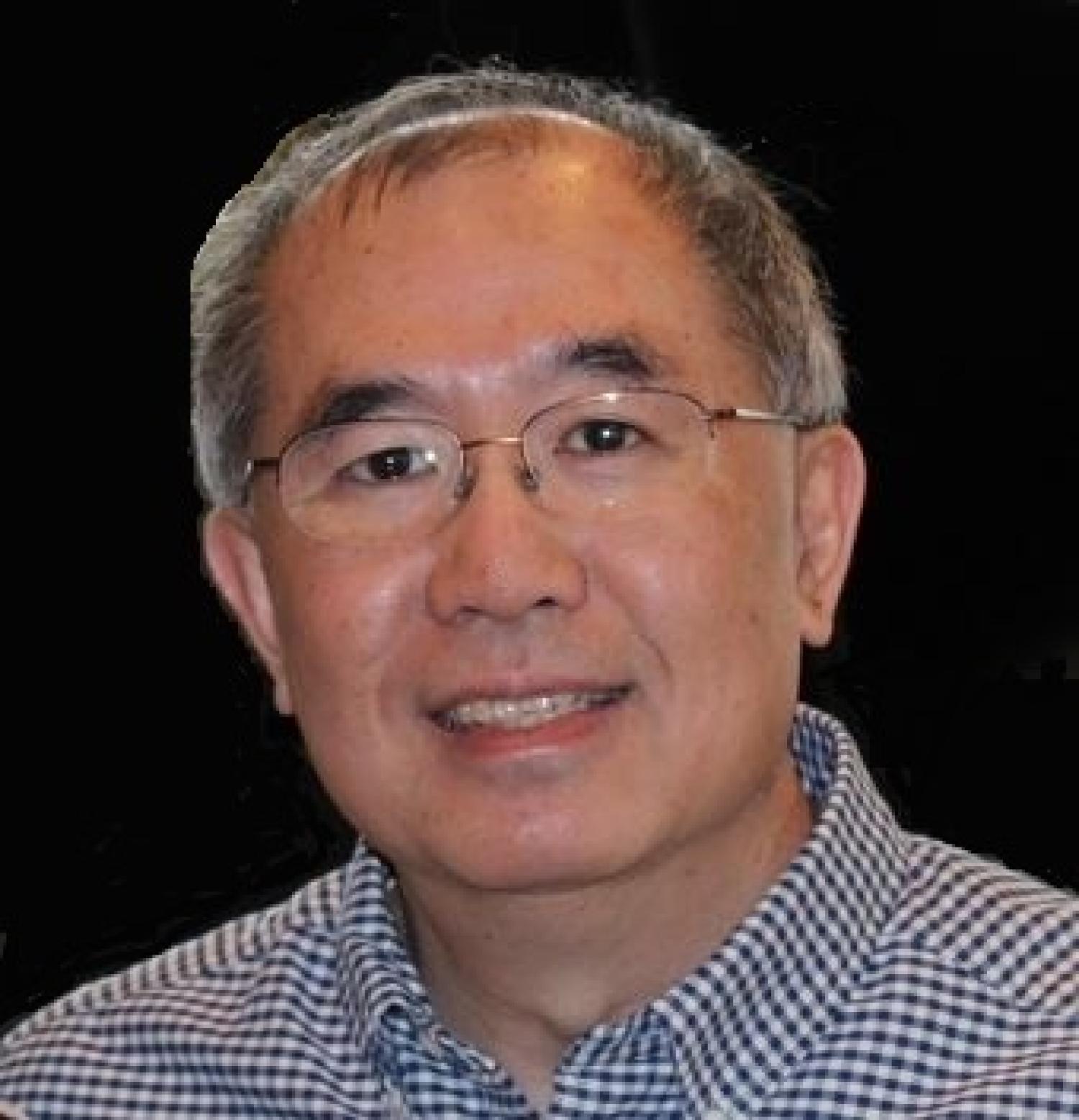 Ron Pak wearing glasses and in a button-down shirt.