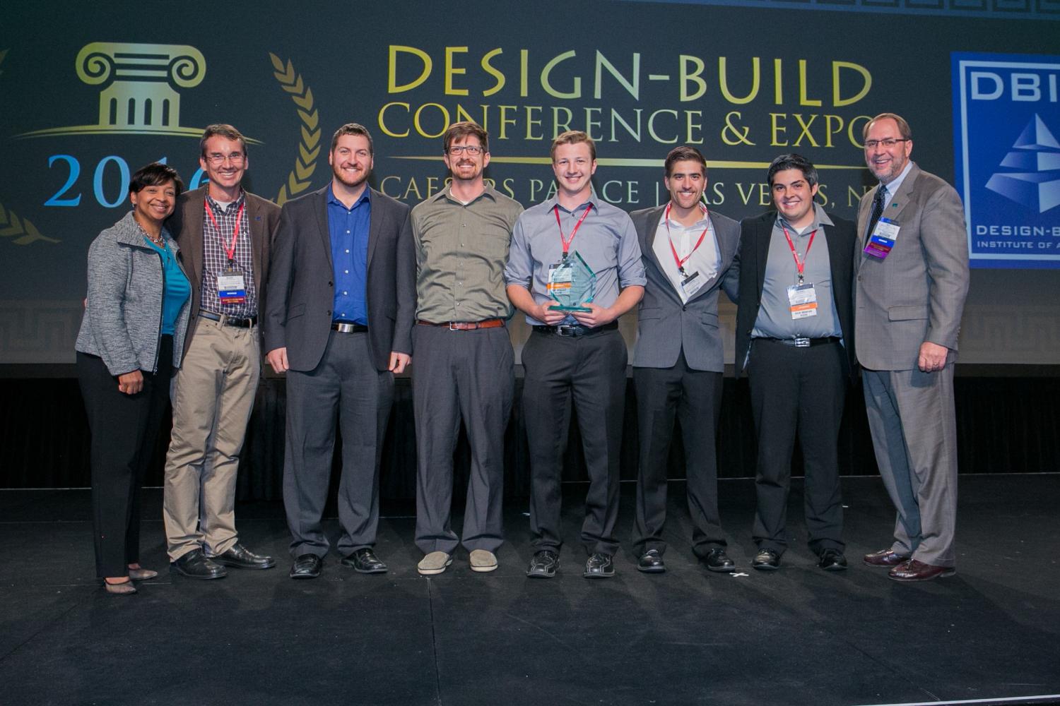The team poses for a group shot on stage after receiving their trophy.