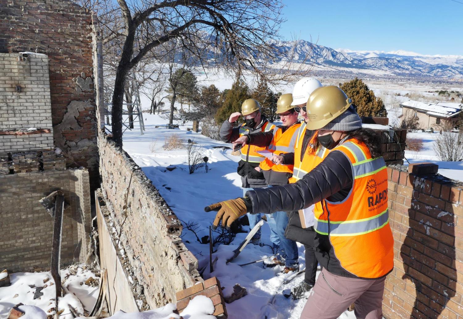 A team of people looking at the remains of a building.
