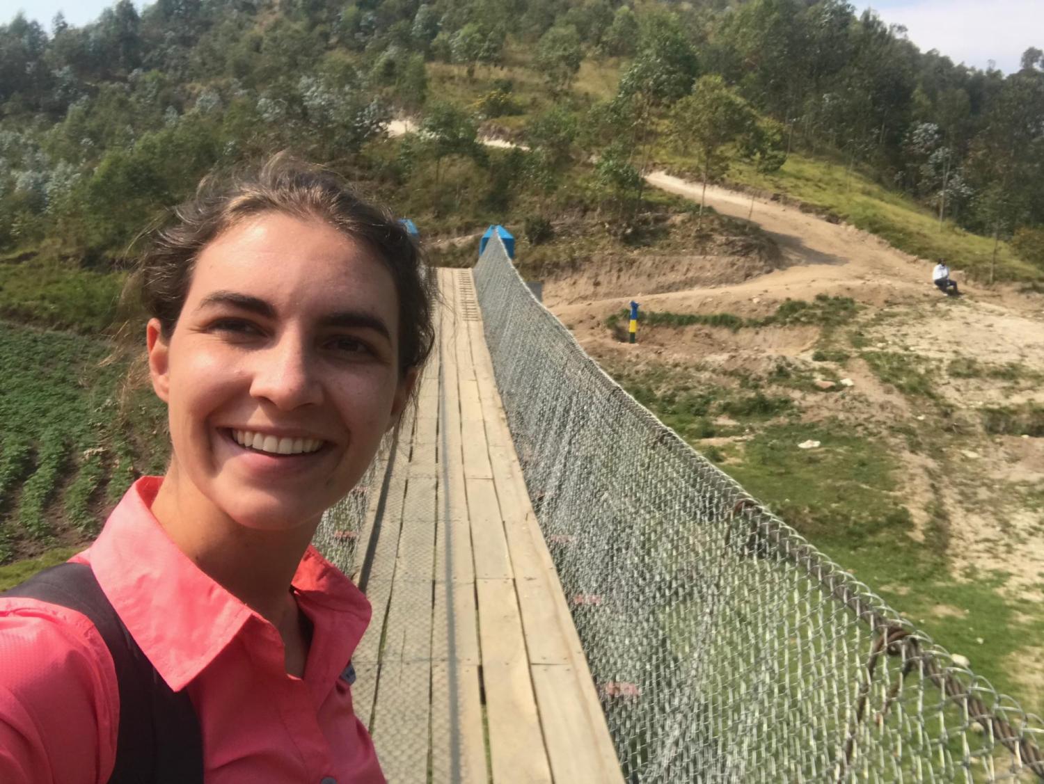 Sally Gerster takes a selfie in front of a Bridges to Prosperity footbridge in Rwanda.