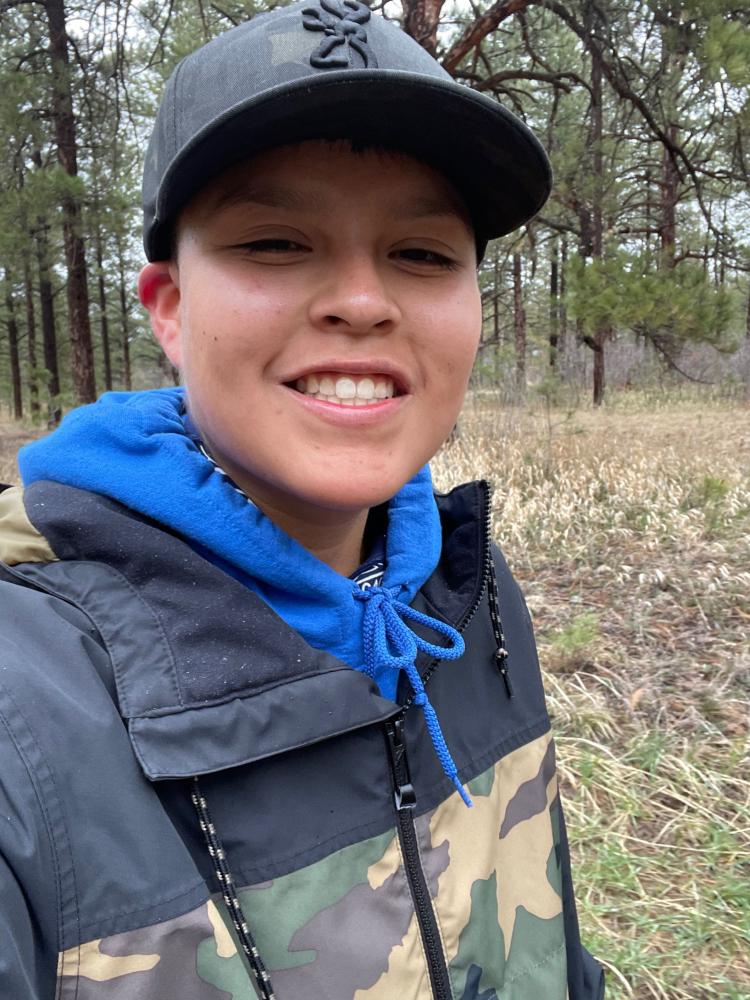Chaya Farley wearing a ball cap and a hoodie sweatshirt that has camouflage on it