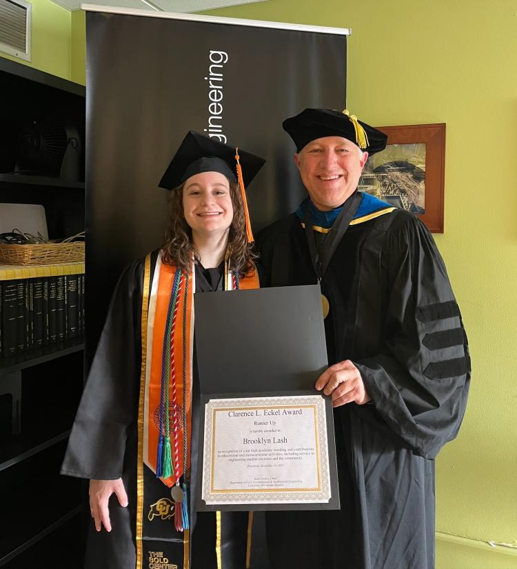 Brooklyn Lash, a civil engineering major stands next to CEAE department chair, Karl Linden. Karl holds the award; both are in graduation regalia
