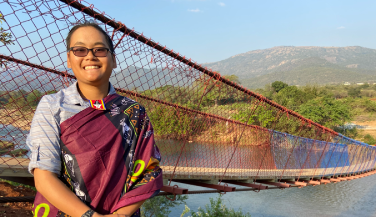 Nina Fromartz next to a long suspension bridge.