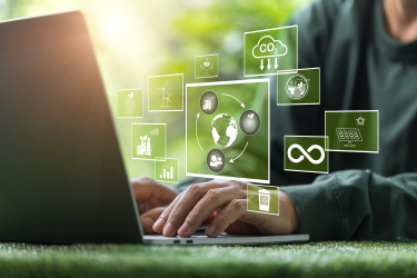 Hands at computer with green in the background representing sustainable computing