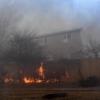 A fence on fire near a home during the Marshall Fire