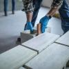 Person with gloves on handling blocks of concrete