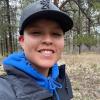Chaya Farley wearing a ball cap and a hoodie sweatshirt that has camouflage on it
