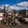Burned cars in front of a burned home.