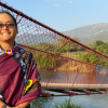 Nina Fromartz next to a long suspension bridge.