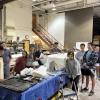 Students getting ready to take the styrofoam mold off of the concrete canoe.