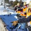 Drone fire research workers in hardhats and reflective gear