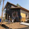Students stand by a zero-energy home they are building.
