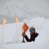 Man in a deep hole shoveling out snow