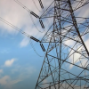 A high voltage electrical grid against a blue sky with clouds