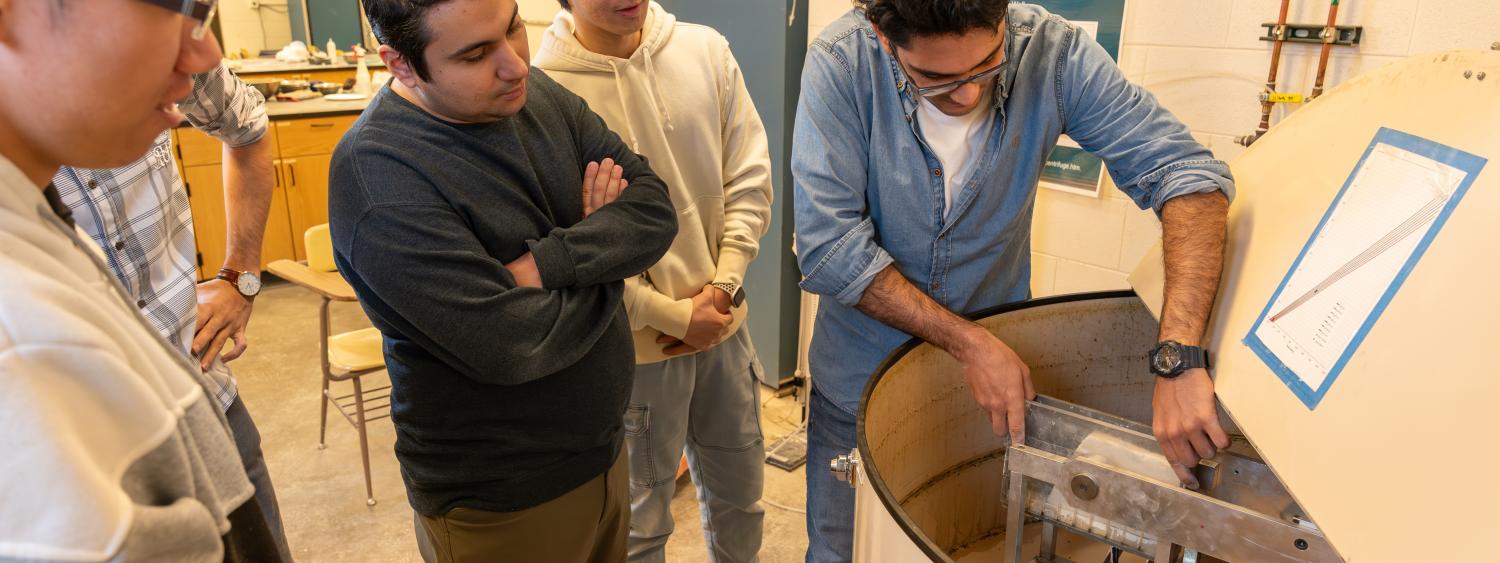 Students in the geotech lab observing a demonstration of a centrifuge.