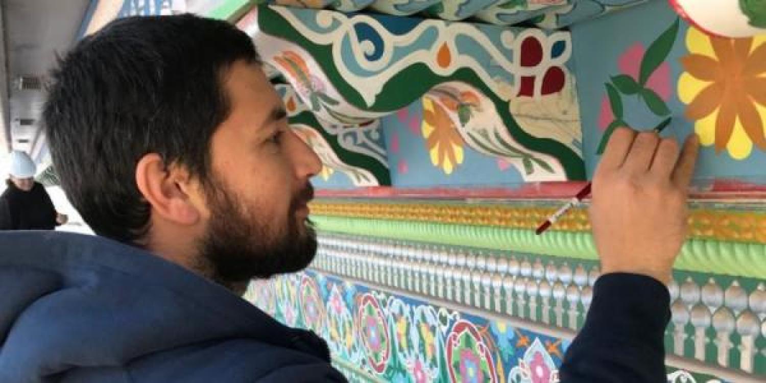Marufjon Mirakhmatov paints the trim on the Boulder Dushanbe Teahouse.
