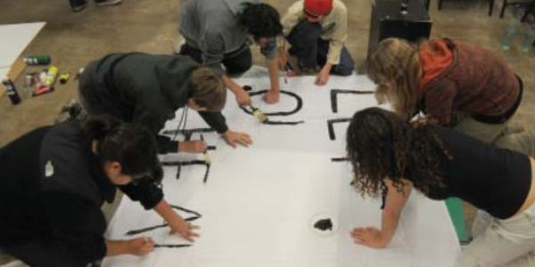 The Youth Engagement Steering Committee painting a banner for the kick-off. 