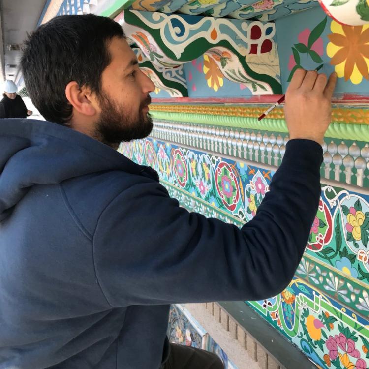 Student  painting the wall of the Boulder Dushanbe teahouse