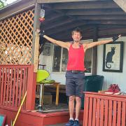 Dave Weil with his hands up on the porch in front of his mobile home.