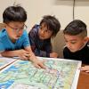 Whittier Elementary first-graders Sean Lee, from left; Tevin Loku Umagiliyage and Eber Garcia-Gonzalez get their first look at a kid-friendly map of Boulder they helped create through Growing Up Boulder. Growing Up Boulder, a collaboration among Boulder, the Boulder Valley School District and the University of Colorado Boulder, worked with about 700 elementary students for the project.