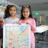 Two young students hold a draft of the child-friendly map