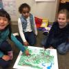 Three children sitting around a map.