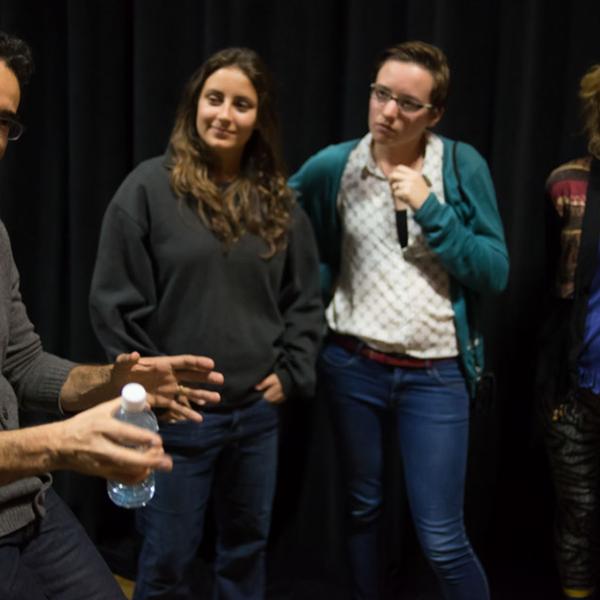 A group of three female students listing to a man discuss science writing