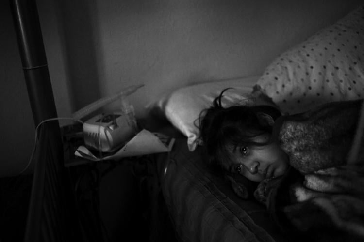 From "The Long Shadow". Caption: Annabel Rodriguez-Santos, 8, lies in bed after a long night of getting little sleep. Annabel had an asthma attack during the night. "There are some nights you don't even sleep because you are just watching over them," said Annabel's mother Nancy Santos. Both Annabel and her older sister have childhood asthma. The family lives in the Elyria-Swansea neighborhood, only a few blocks from the construction on the Central 70 project. (Photo by RJ Sangosti/The Denver Post)