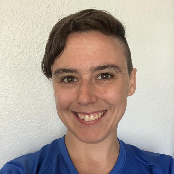Selfie of Mindy, a brown-eyed, brown-haired person wearing a blue shirt.