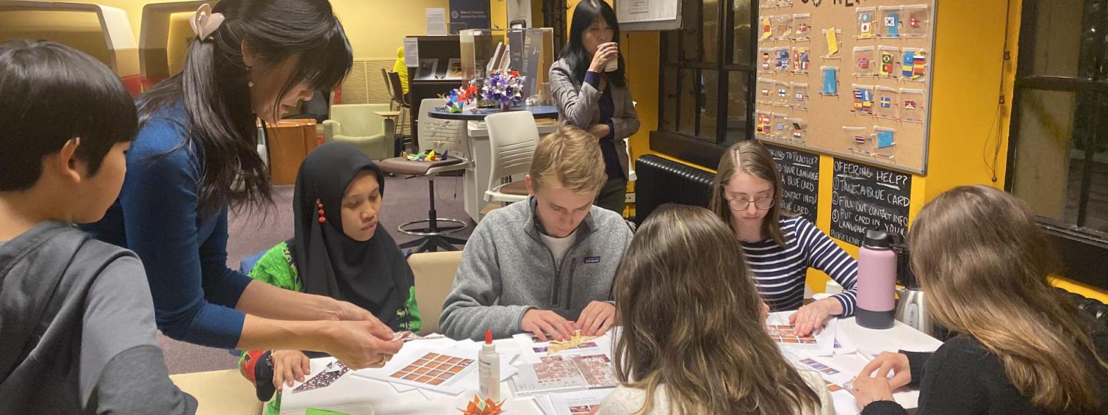 People folding origami at a table