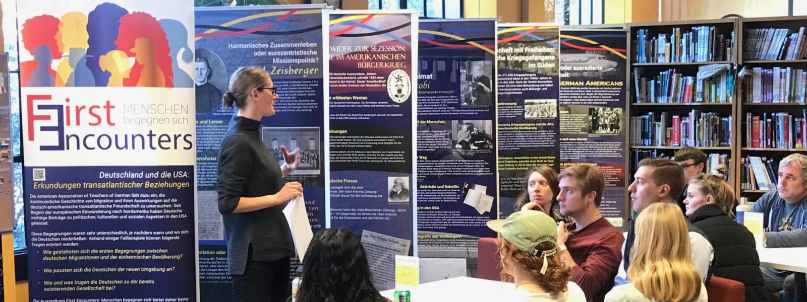 teacher talking to students in front of exhibit