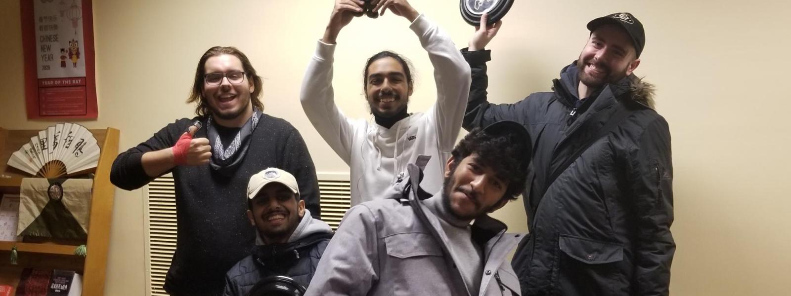 People holding up a trophy after winning a karaoke competition