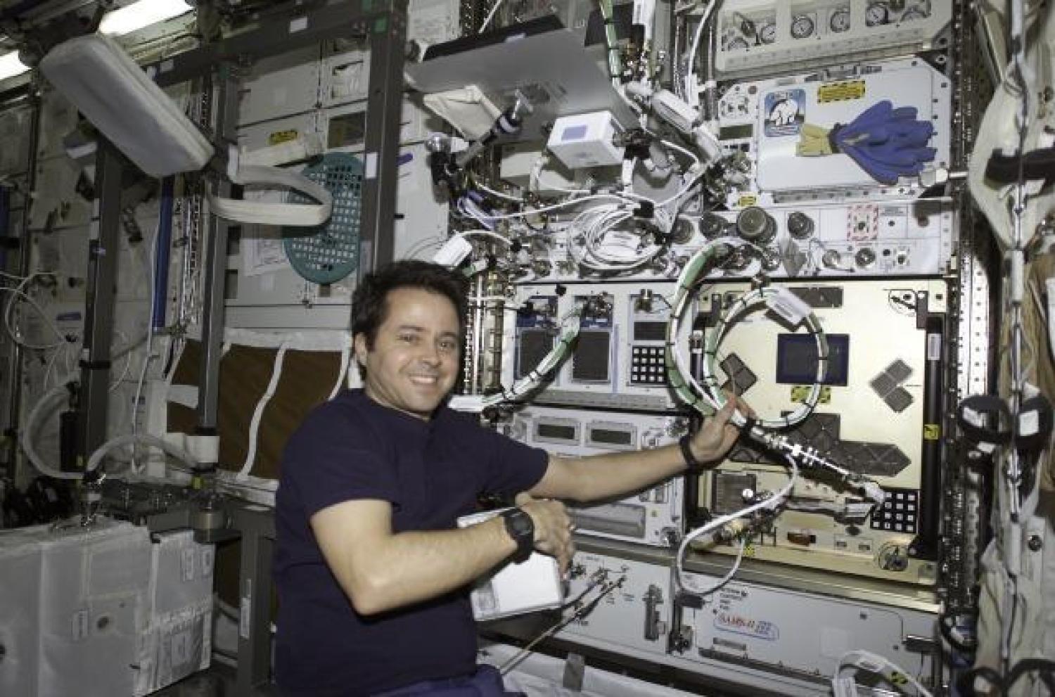 NASA astronaut Dan Bursch in front of CGBA installed into an EXPRESS rack
