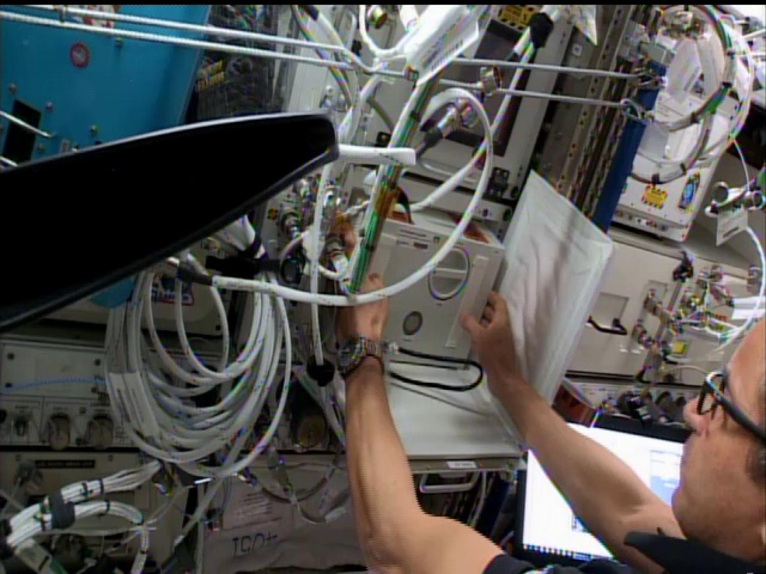 Astronaut installing ACM into SABL on ISS