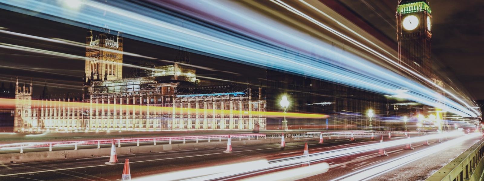 Time lapse of Big Ben in London at night with cars whizzing by.
