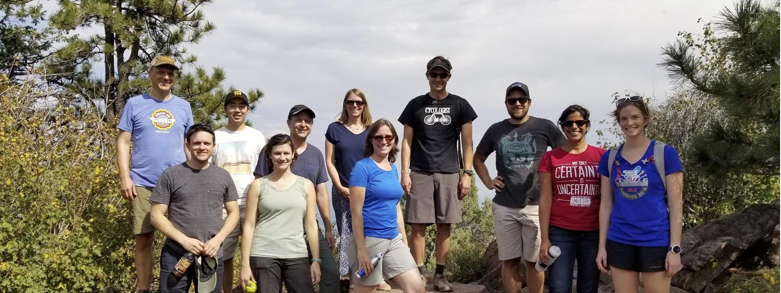 10 people on a rock ledge, hiking, sunny day