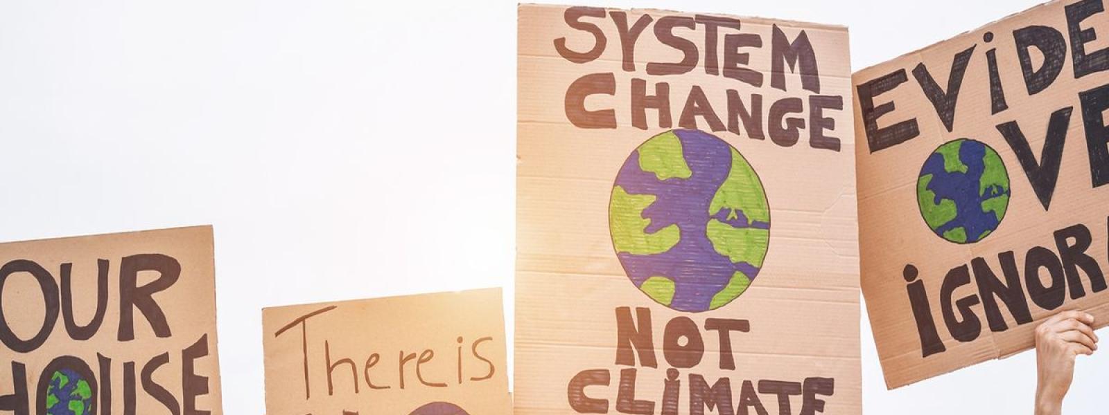 banners w/ slogans, "system change not climate change" protest