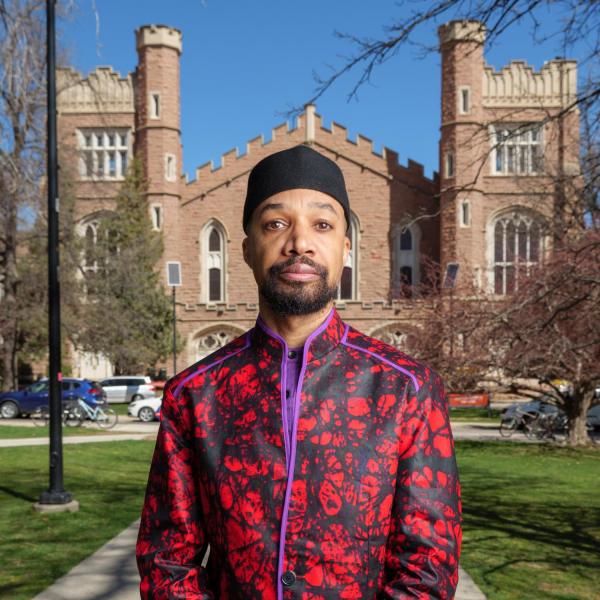 Reiland Rabaka standing in front of Mack Auditorium wearing red.