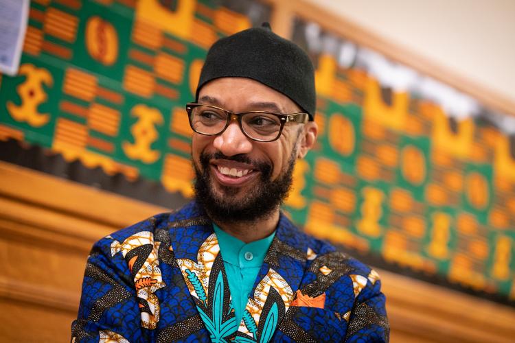 Professor Reiland Rabaka photographed in front of a color board in Macky Auditorium.