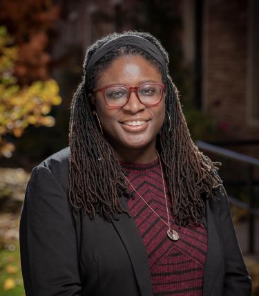 Assistant Professor Ashleigh Lawrence-Sanders photographed in front of a neutral background.