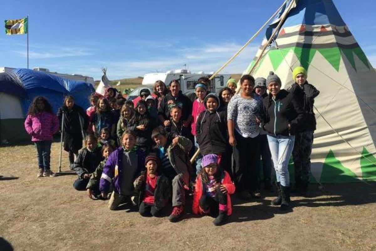 group of individuals by a teepee