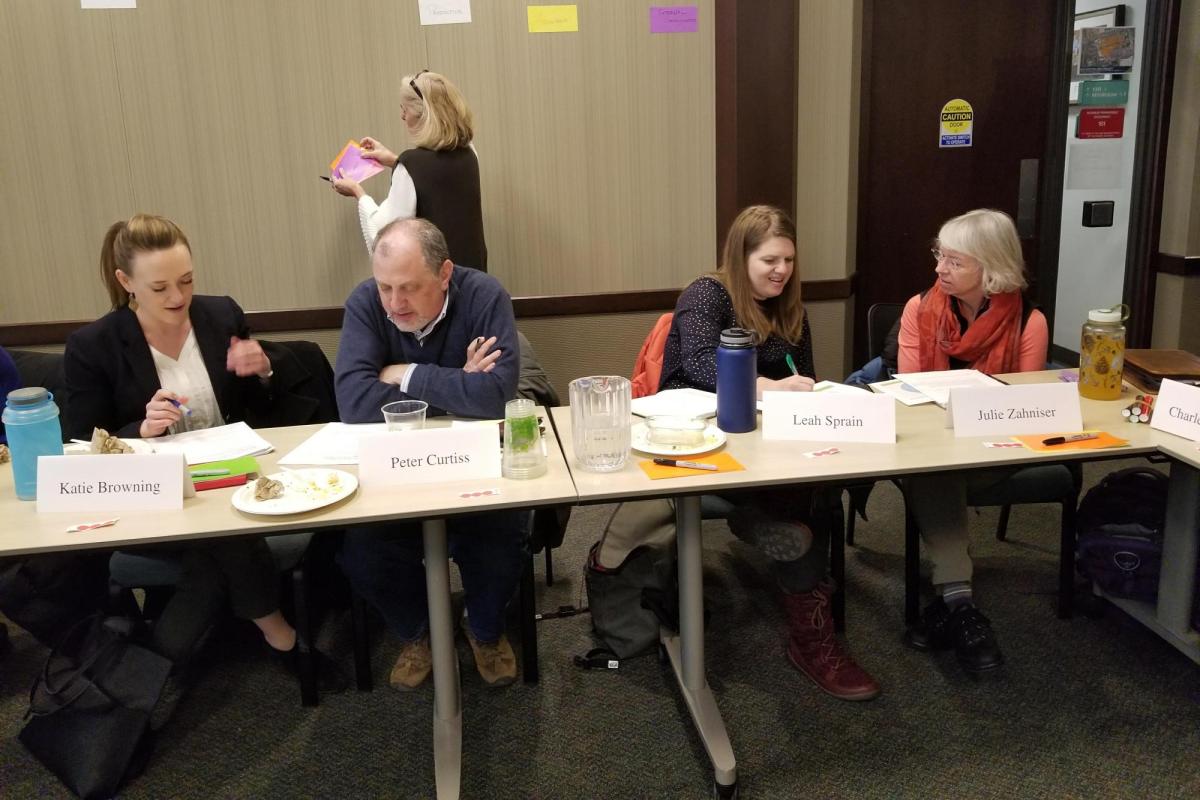 group of individuals discussing amongst each other at table