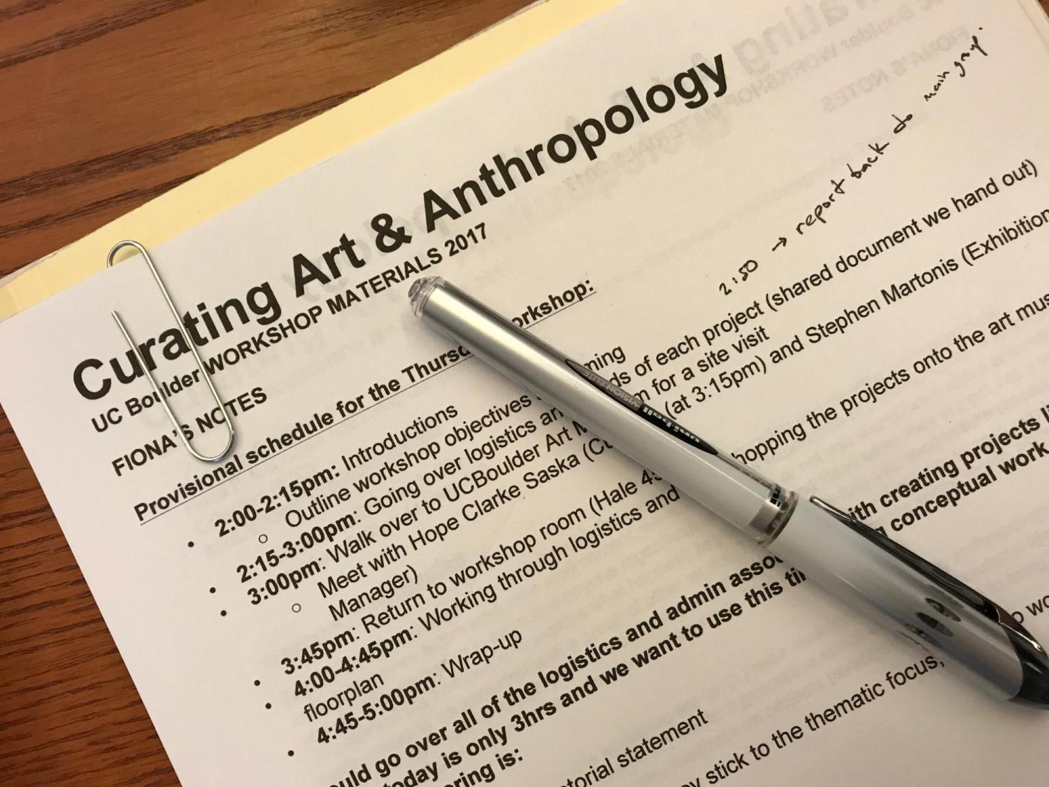 Curating Art and Anthropology workshop materials document with pen.