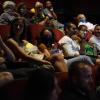 An audience sits in crowded theater.