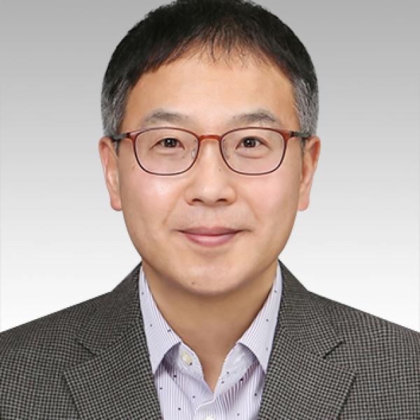 Sam Sohn wearing glasses. He is in a suit jacket and button-down shirt.